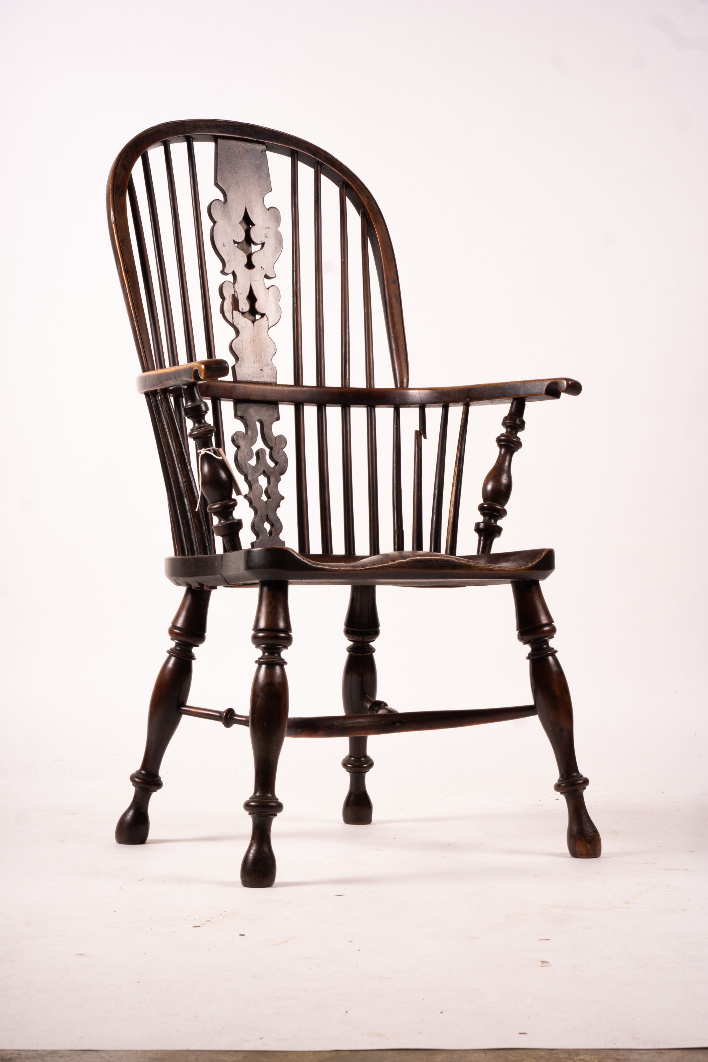 A mid 19th century yew and elm Yorkshire area Windsor armchair with saddle-seat and crinoline stretcher, width 63cm, depth 47cm, height 110cm